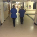 Staff walking down hospital corridor