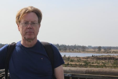 A man standing in front of a landscape